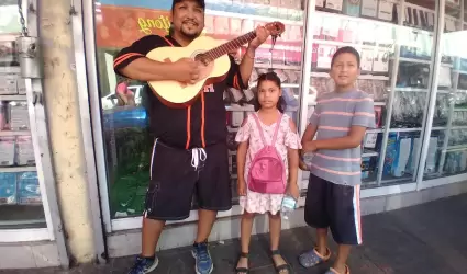 Nios acompaados de su padre cantan en calles del Centro para recaudar dinero y