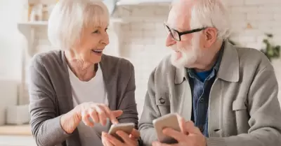 Pareja de ancianos y abuelos esposos que usan telfonos celulares inteligentes j