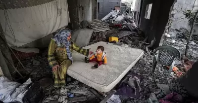 Una mujer palestina y su hijo, en el interior de una casa bombardeada en Gaza.