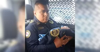 Oficial de la policía con bebé en brazos