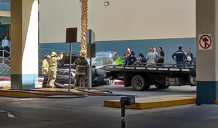Mujer cae con su carro del segundo nivel de un estacionamiento